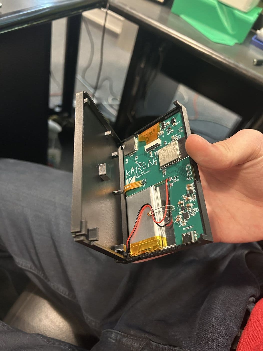 The Kairon enclosure opened to show its custom circuit board, battery and display